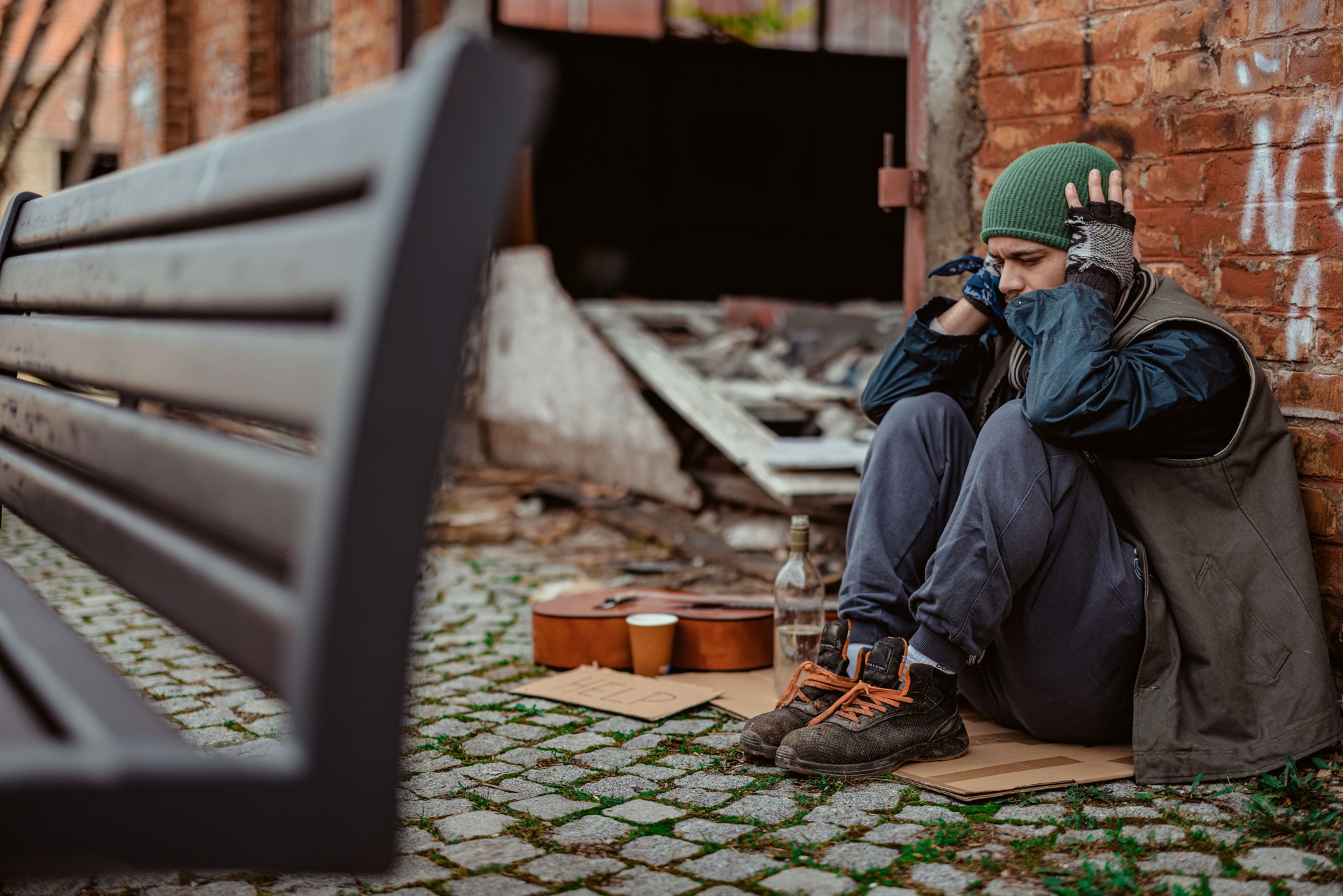 Homeless Man Sitting in Front of an Abandoned Building